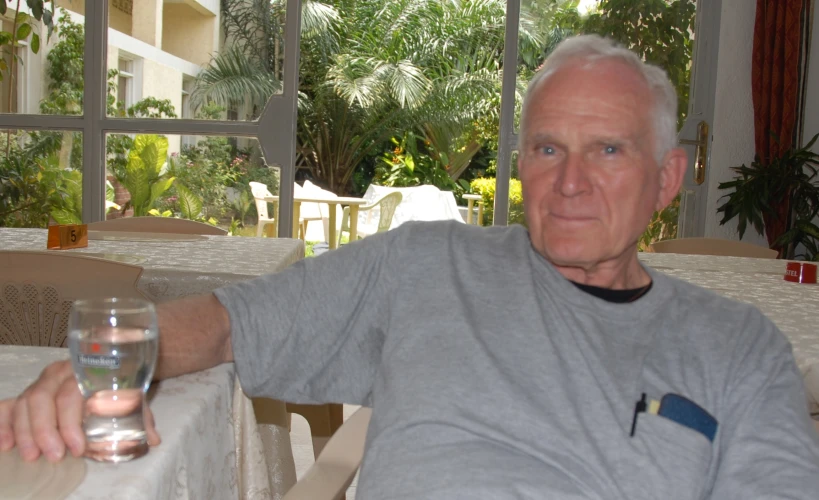 an older man is sitting down and holding a wine glass