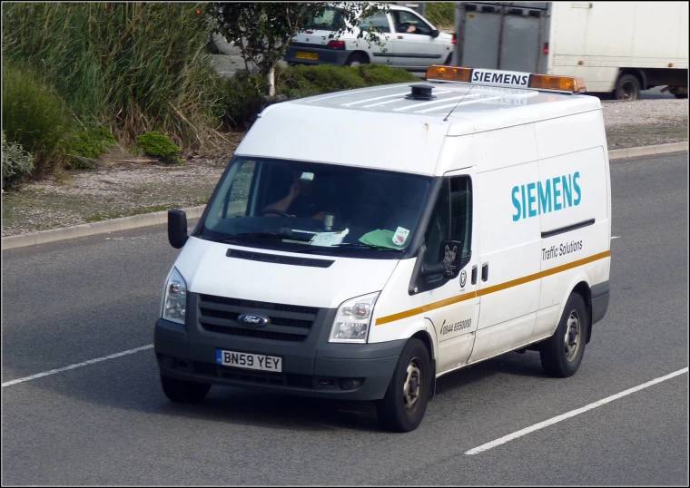 a white van driving down a street next to a parking meter