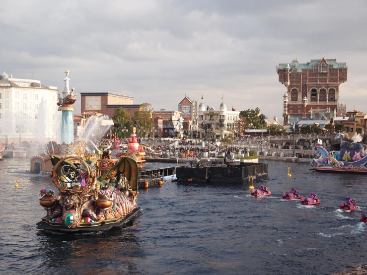 several small boats traveling on a body of water in front of a town