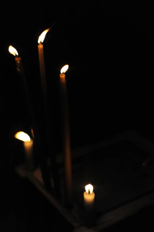 candles lit on an ash stick in the dark