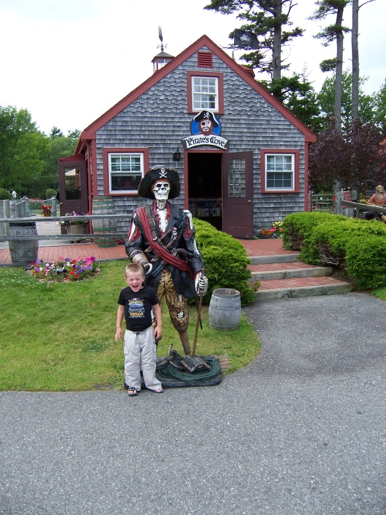 a boy and his son in front of a pirate's shack