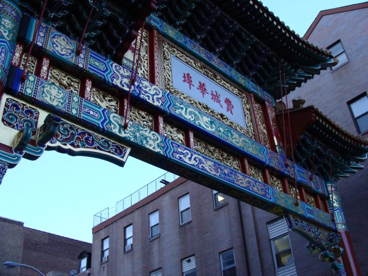 the arch of an asian oriental building with an open sign below it