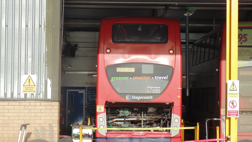 the red bus is in the garage underneath the door