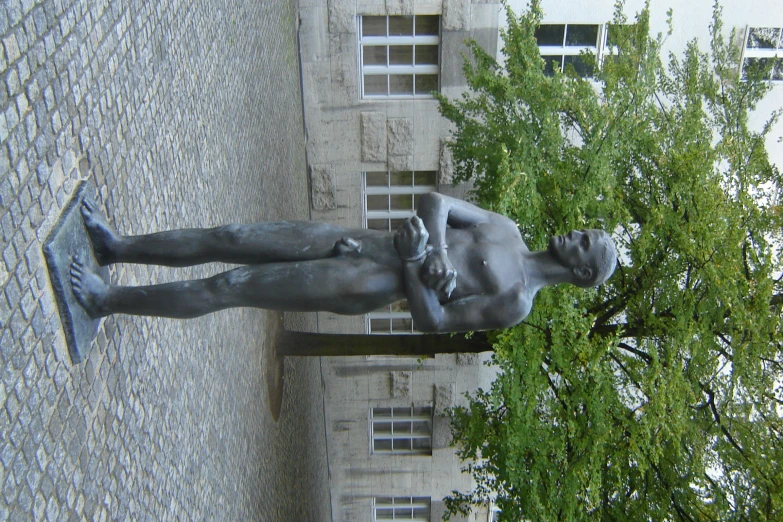 a statue is laying in front of a building