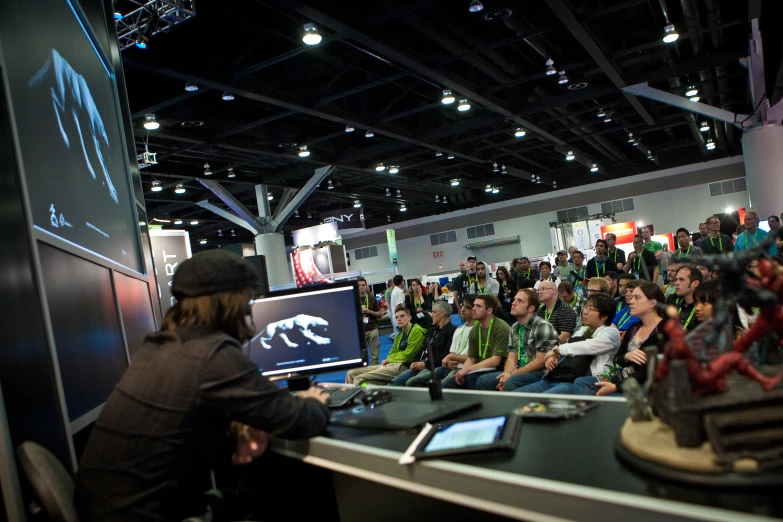 a man using a laptop in front of a crowd