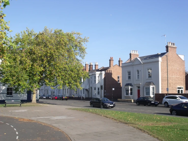 the front yard and street are lined with large, red brick homes