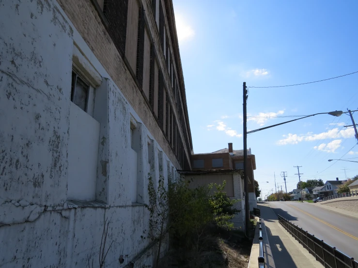 an old building on a road beside some street lights