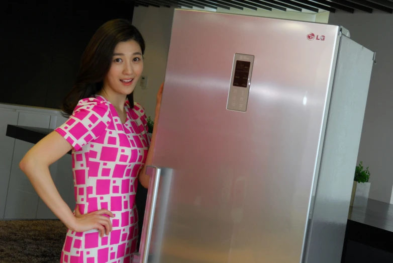 a woman standing next to an appliance in a kitchen