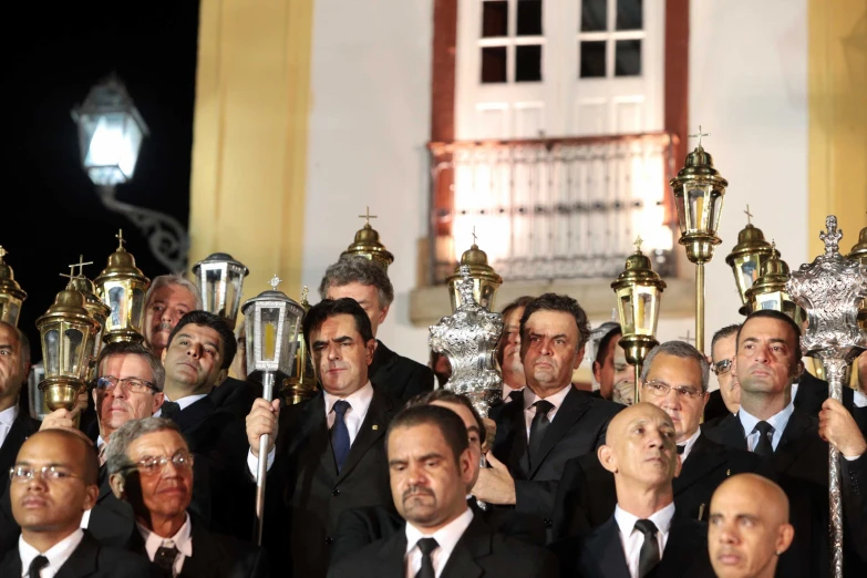 a group of men dressed in suits holding up trophies