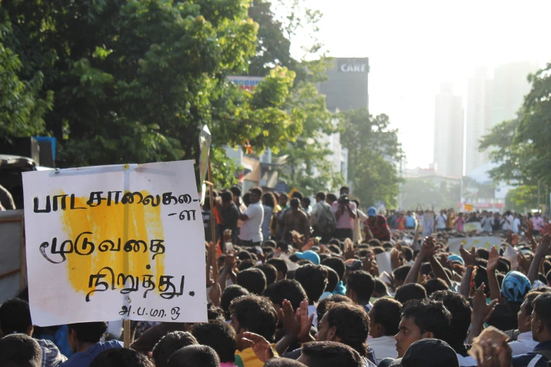 a group of people standing around with a sign