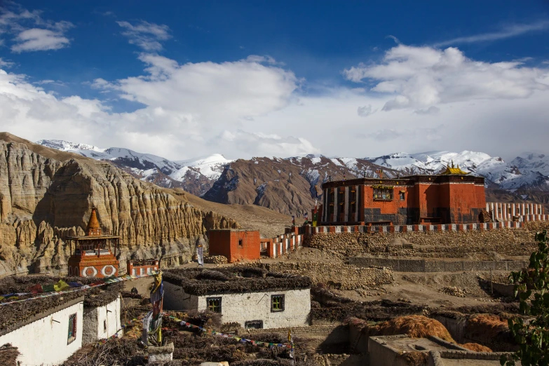 a town in the mountains with some snow covered mountains