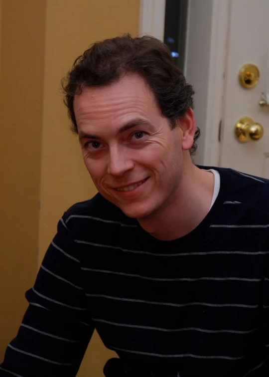 a man in a striped shirt sitting down