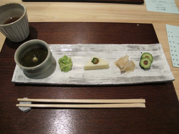 a wooden tray with chopsticks and sushi on it