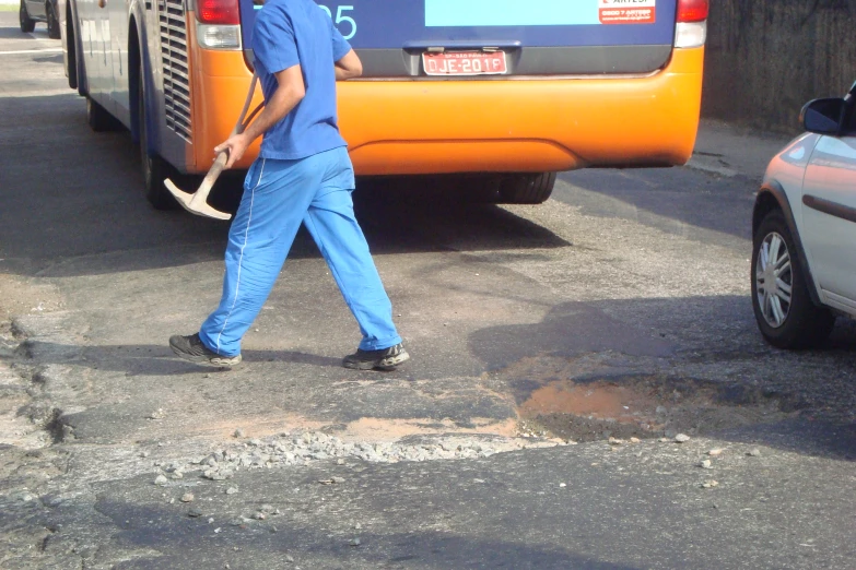 the worker in blue jumpsuit is crossing a crosswalk