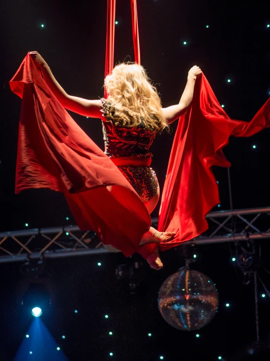 a woman with very long hair is suspended on two ropes