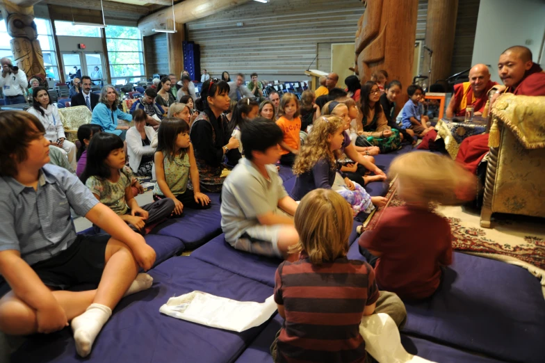 a number of people sitting and standing in front of a large group of people