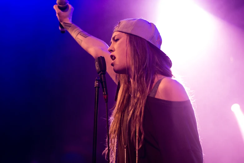 a woman singing into a microphone on stage