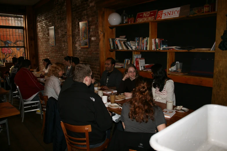 people are sitting around the table enjoying food