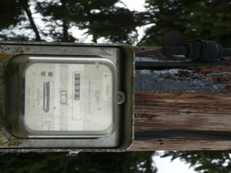 a telephone pole with a rusted sign on it