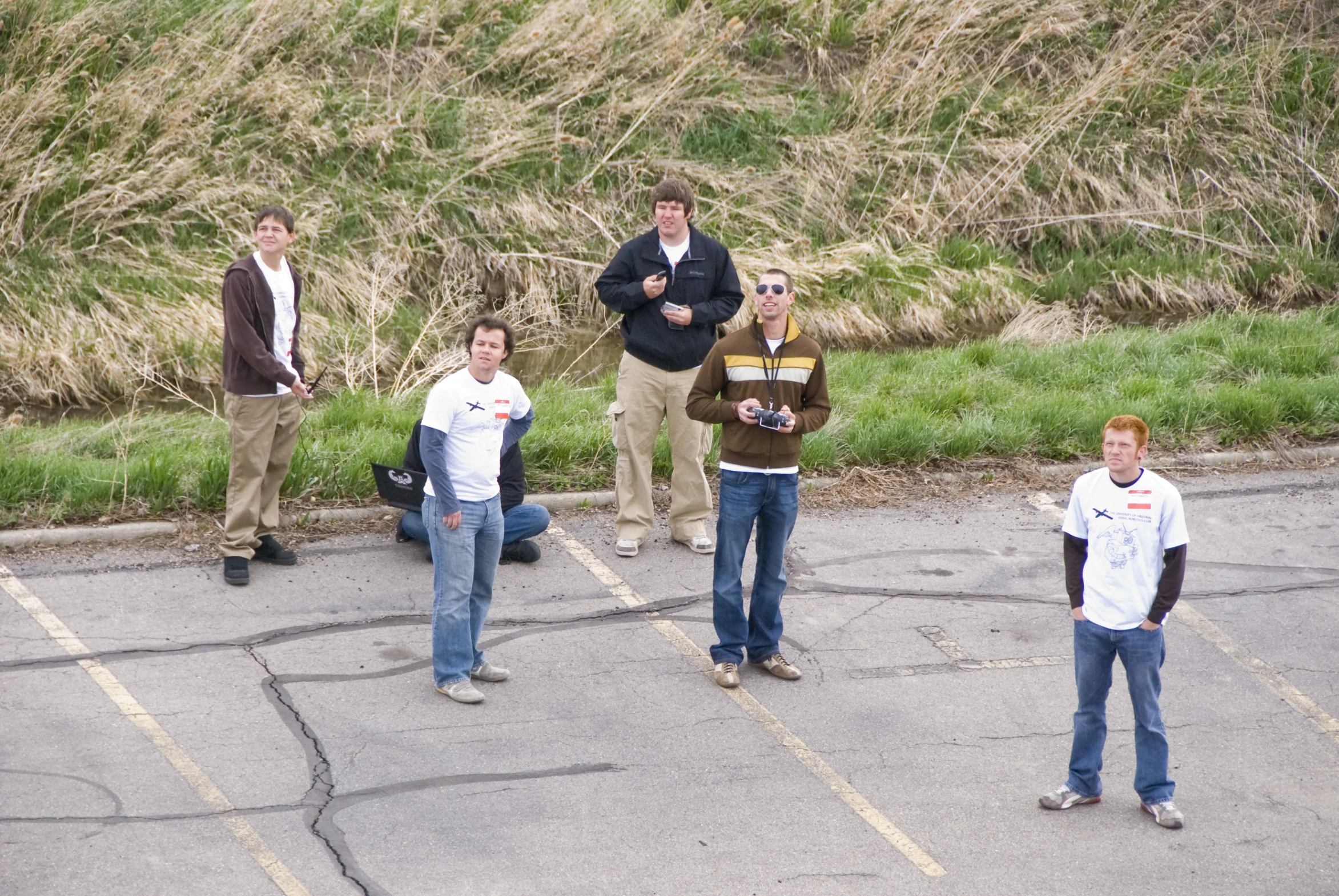 a group of people standing around a parking lot