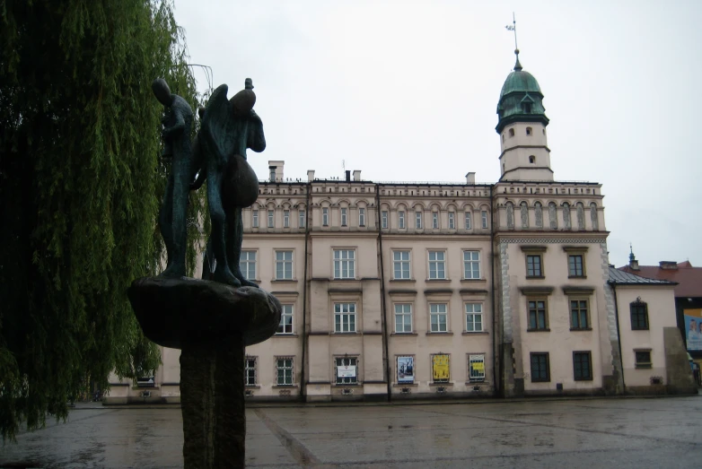 a large brown building with a statue in front