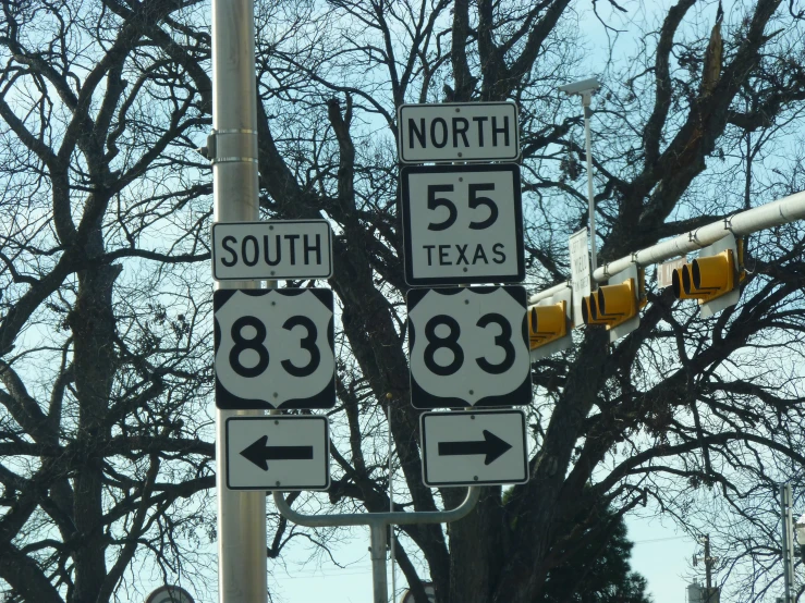 several signs on a pole are in the foreground