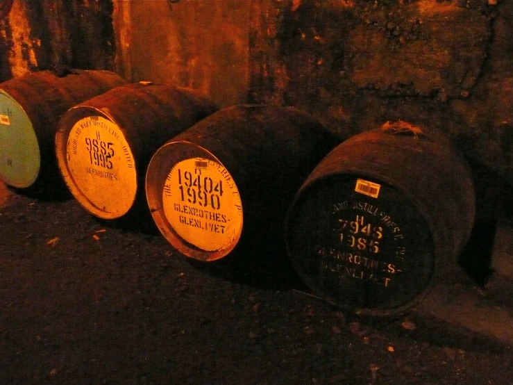 the old and broken wine barrels are next to the wall