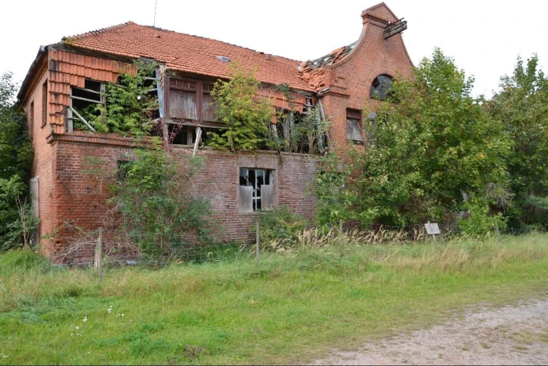 an abandoned house in the country with overgrown vegetation on the roof