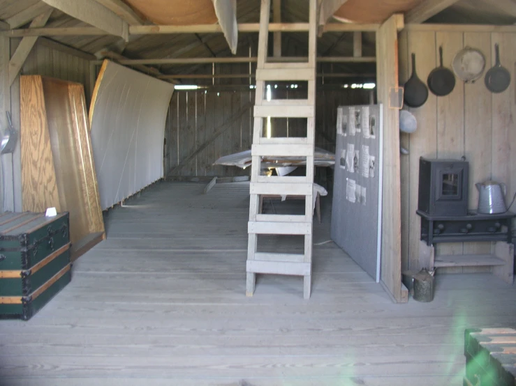 a rustic, open area with a long ladder leading up the side