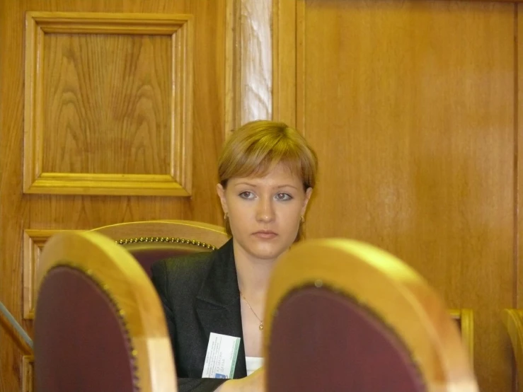 there is a young woman sitting in a wooden chair