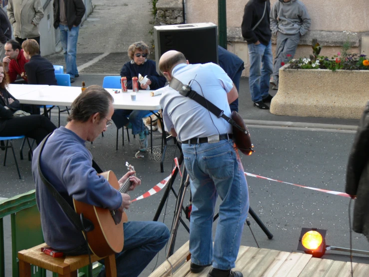 a man is playing a guitar in the street