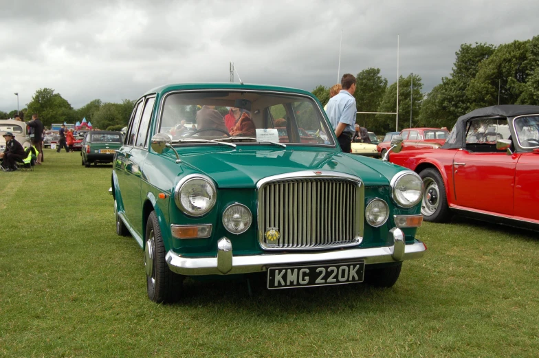 a green classic car on display at a show