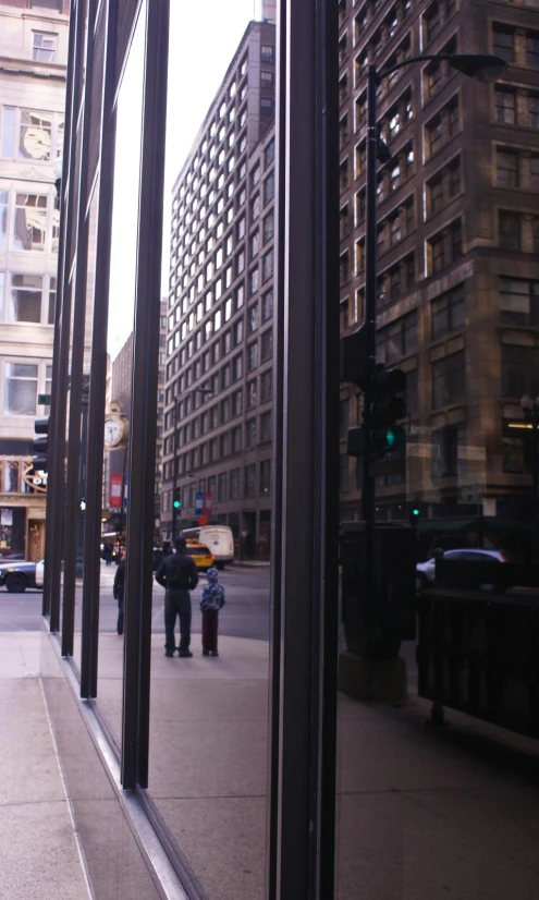 looking outside a tall glass window with a reflection of a street