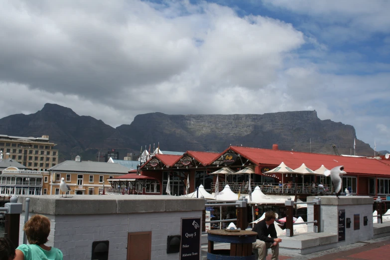 a city plaza with mountains and buildings in the background