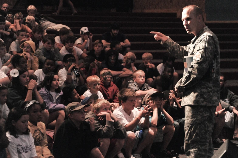 a man in uniform standing at attention to an audience