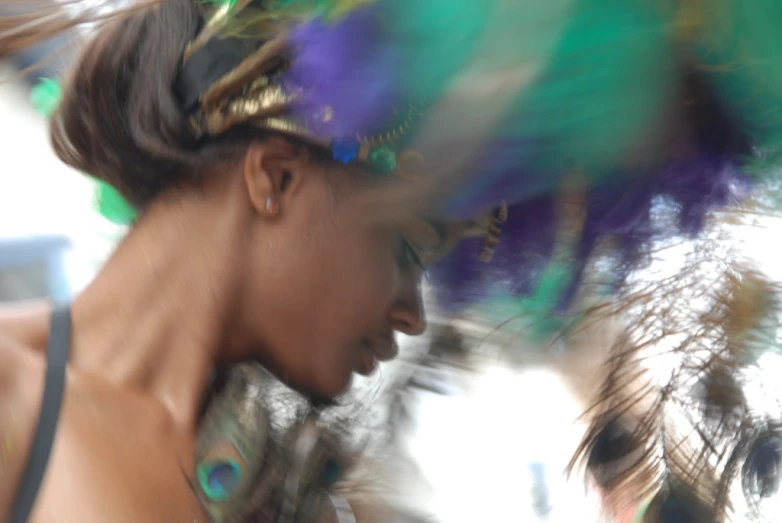 blurred image of woman with colorful feathers at festival