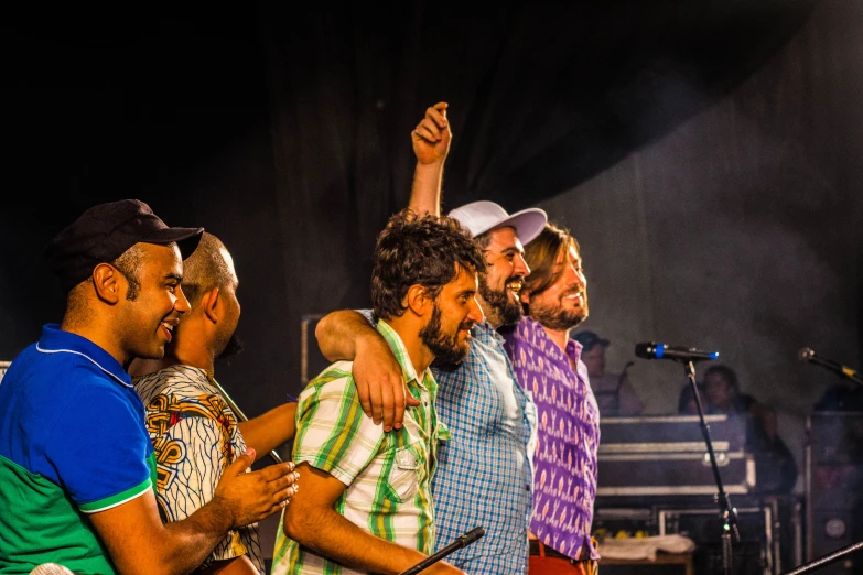 a group of men standing on top of a stage