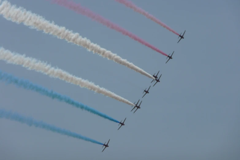 nine airplanes flying in the sky leaving vapor trails