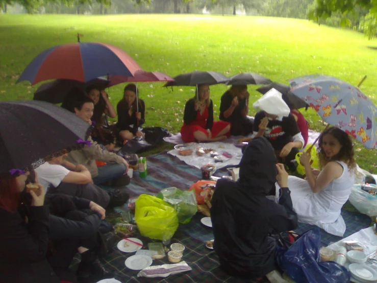 a group of women who are sitting down under umbrellas