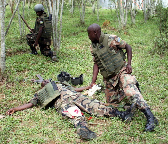 soldiers in camouflage look at the  of an injured soldier