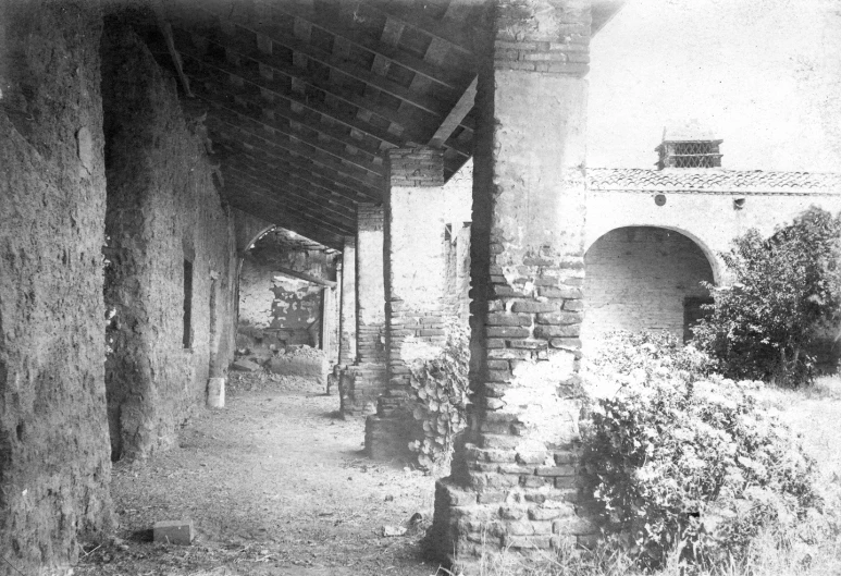 the alley has brick pillars leading to several chimneys