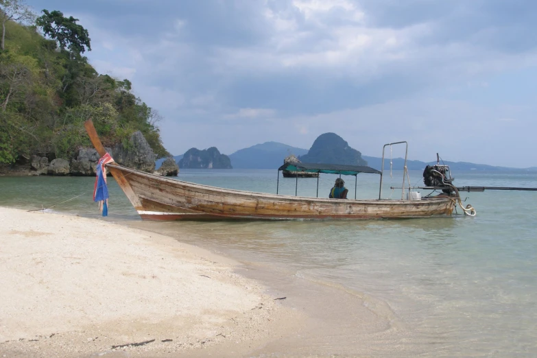 a boat sits empty on the shore at the beach