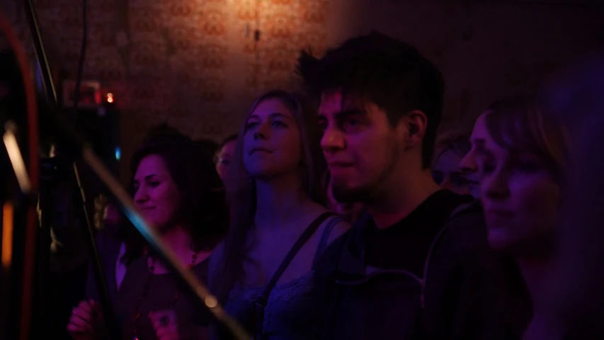 group of young adults looking into distance in darkened room