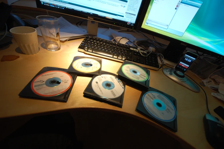 several cd cases next to a computer monitor