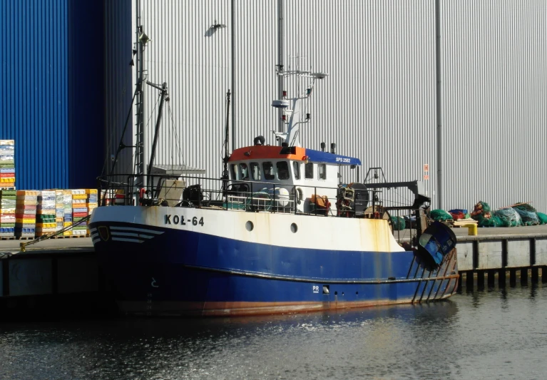 a fishing boat docked at the dock outside a building