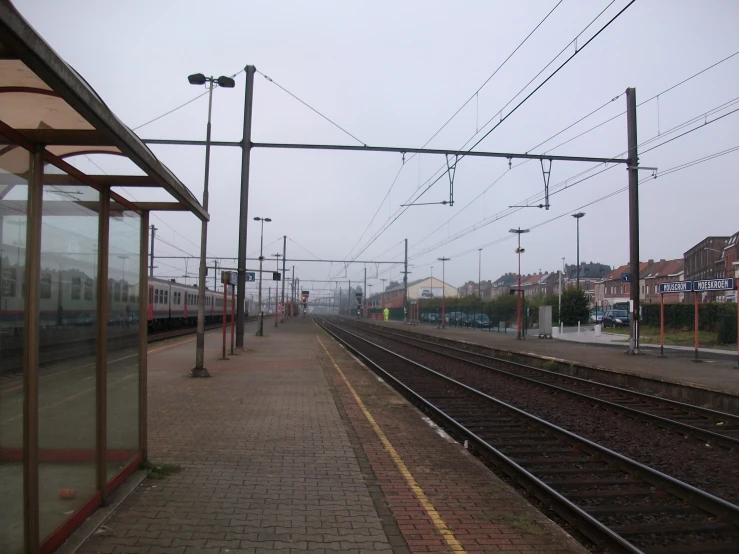 a walkway that has a train station and two buildings on the other side