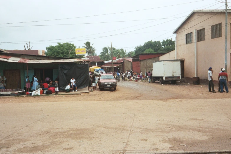 a large group of people walk down a small dirt road