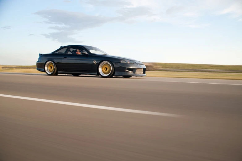 a black and gold sports car with yellow tires