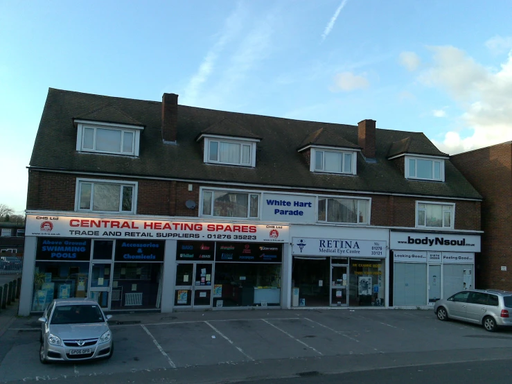 the front of an older retail store with a car parked in front of it