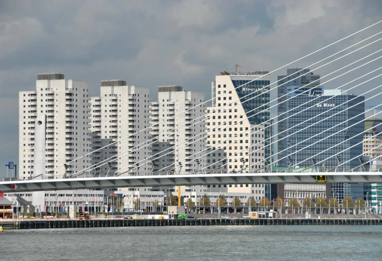 a bridge crossing over water in front of some tall buildings